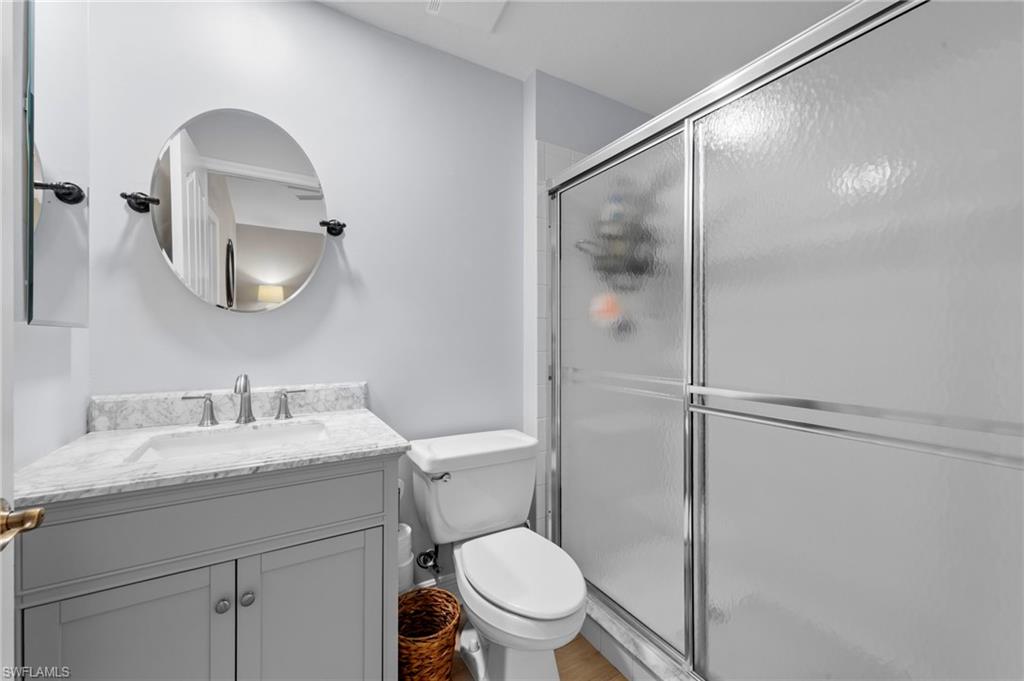 5720 Grande Reserve Way, Unit 2004 Naples, FL 34110 - Photo 16 of 27 a bathroom with a toilet a sink and mirror