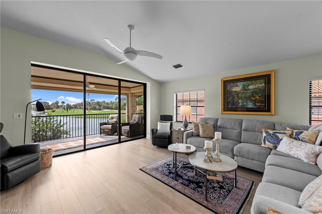 5720 Grande Reserve Way, Unit 2004 Naples, FL 34110 - Photo 3 of 27 a living room with furniture a flat screen tv and a floor to ceiling window