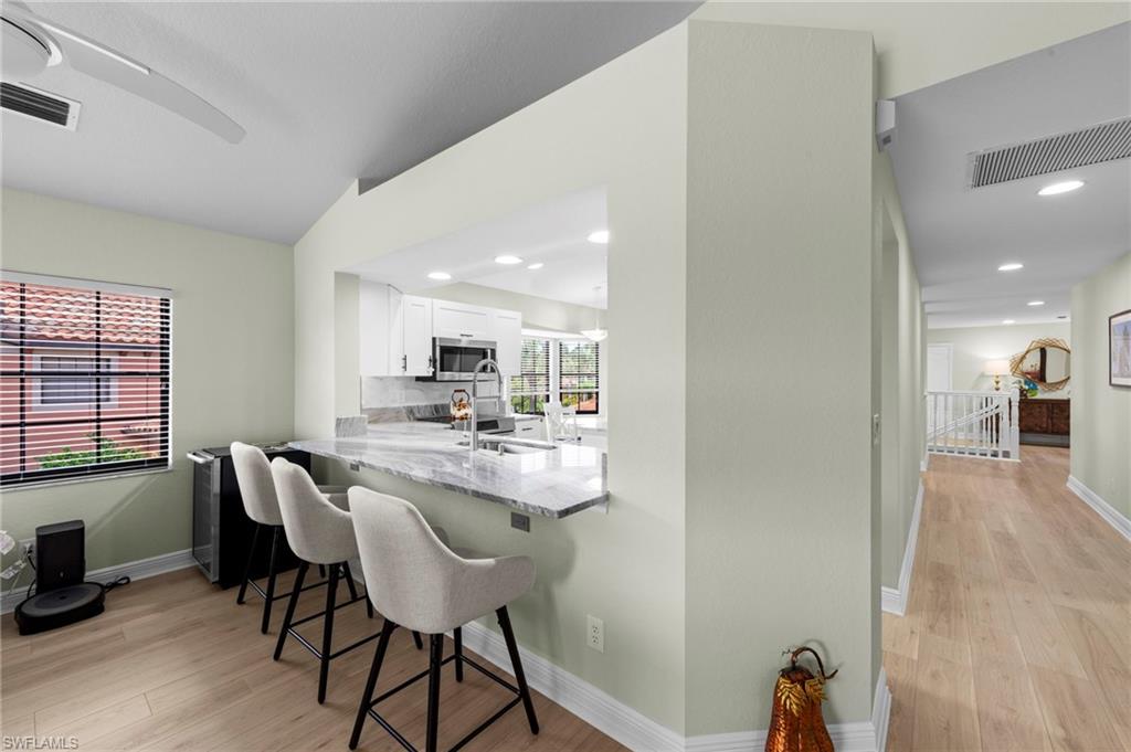 5720 Grande Reserve Way, Unit 2004 Naples, FL 34110 - Photo 5 of 27 a view of a dining room with furniture and wooden floor