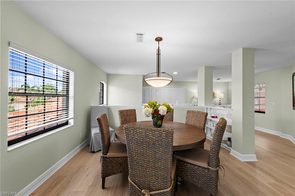 5720 Grande Reserve Way, Unit 2004 Naples, FL 34110 - Photo 9 of 27 a dining room with furniture a chandelier and wooden floor