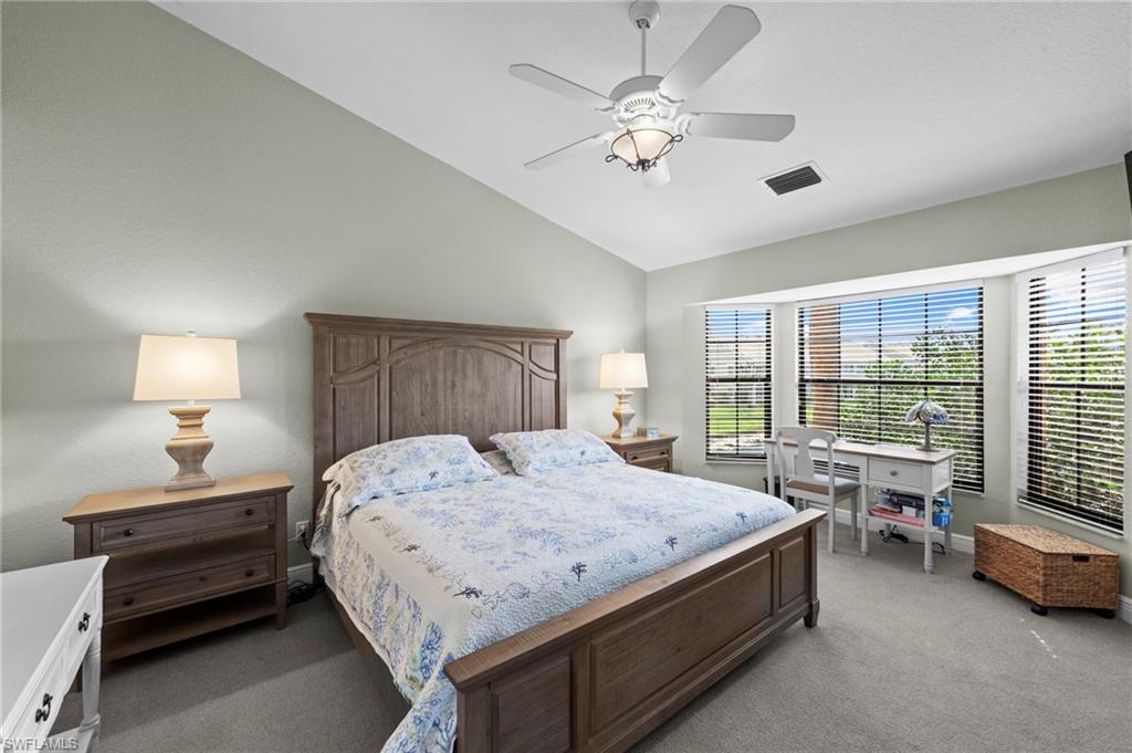 5720 Grande Reserve Way, Unit 2004 Naples, FL 34110 - Photo 10 of 27 a spacious bedroom with a bed and a chandelier