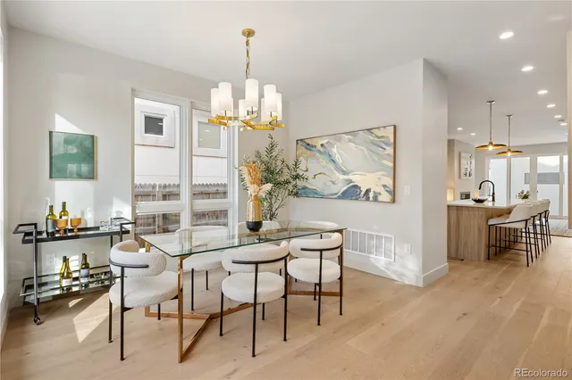 a dining room with furniture a chandelier and wooden floor