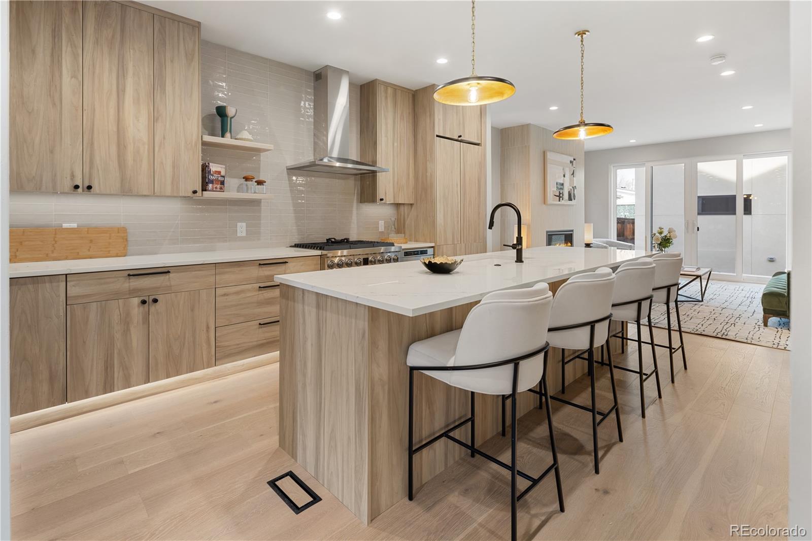 4572 North Raleigh Street Denver, CO 80212 - Photo 5 of 50 a kitchen with stainless steel appliances granite countertop a stove a sink a dining table and chairs with wooden floor
