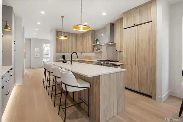a kitchen with stainless steel appliances a table chairs and a refrigerator