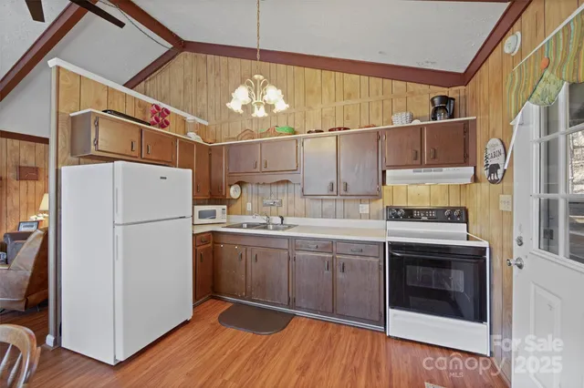 a dining room with furniture a chandelier and wooden floor