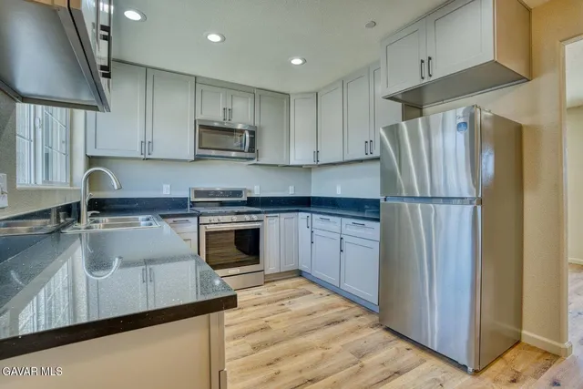 a kitchen with a sink stainless steel appliances and cabinets