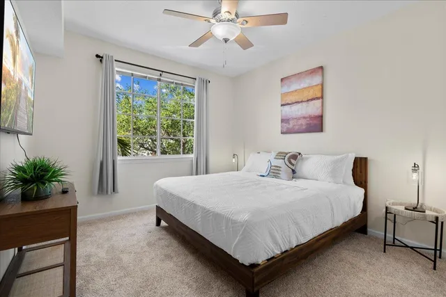 a bedroom with a bed lamp and a large window