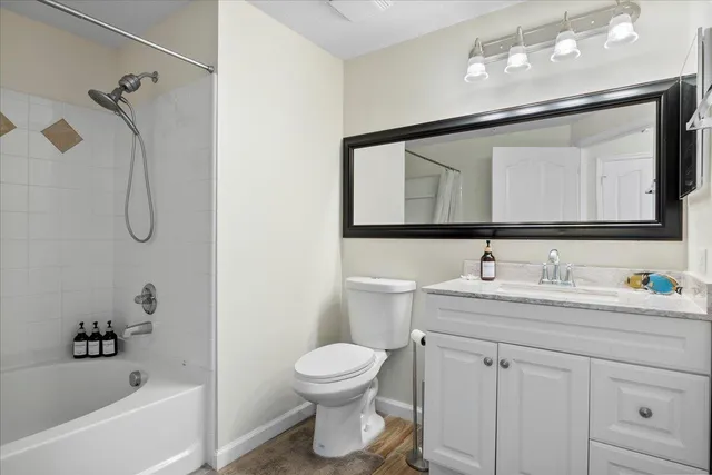 a bathroom with a toilet sink a mirror a bathtub and shower