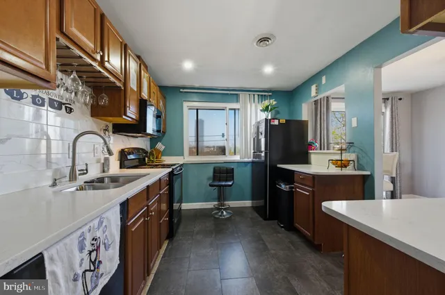 a kitchen with stainless steel appliances granite countertop a sink a stove and a refrigerator