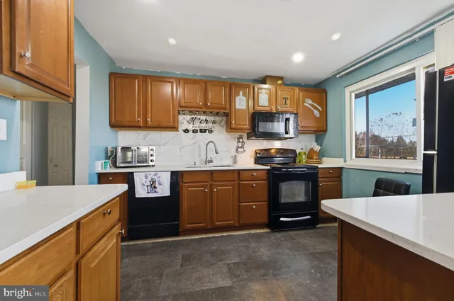 a kitchen with granite countertop a stove top oven sink and cabinets