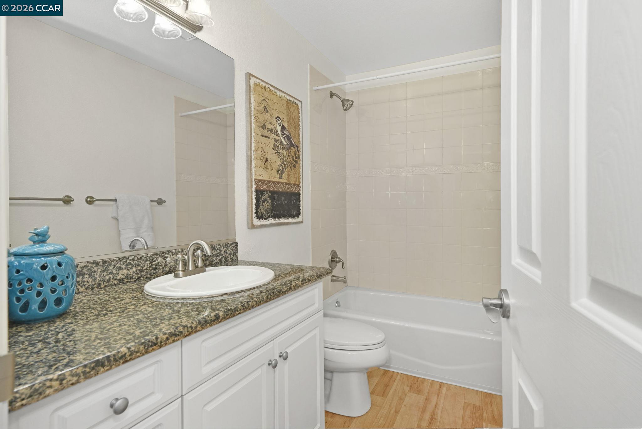 440 Bollinger Canyon Lane, Unit 396 San Ramon, CA 94582 - Photo 17 of 24 a bathroom with a granite countertop sink toilet and shower