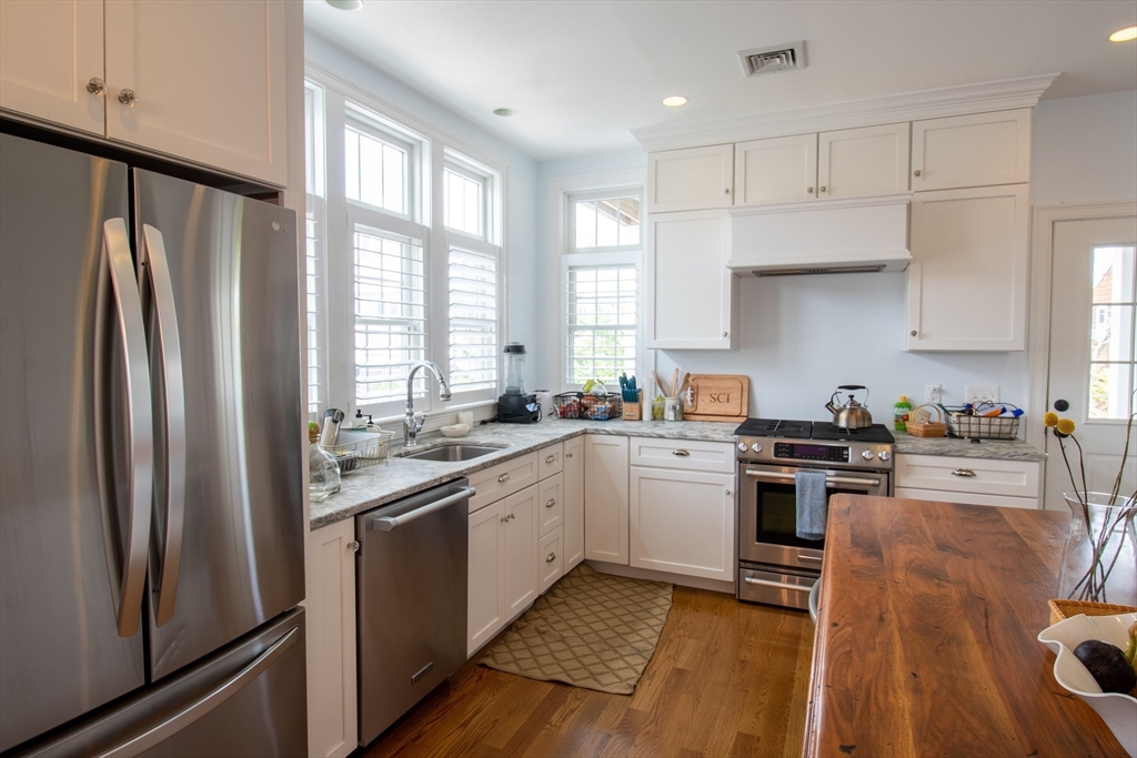 117 River Street Scituate, MA 02050 - Photo 8 of 23 a kitchen with stainless steel appliances granite countertop a stove a sink dishwasher a refrigerator and white cabinets with wooden floor