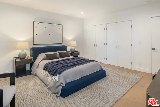 a bedroom with a bed and painting on the wall