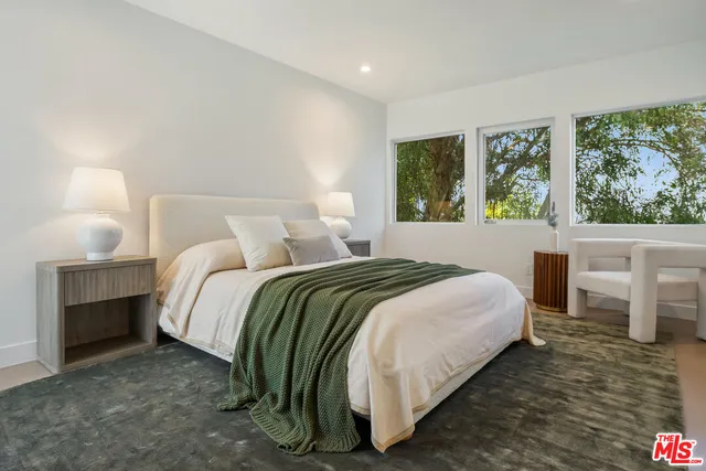 a bedroom with a bed and a large window