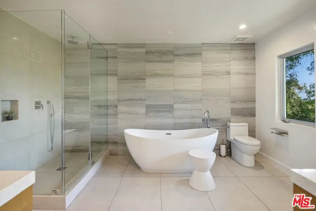 a bathroom with a double vanity sink mirror and bathtub