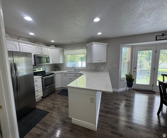 1976 River Bottom Road Springville, UT 84663 - Photo 11 of 45 Kitchen featuring white cabinetry, stainless steel appliances, a white countertop island, and wood-finish flooring