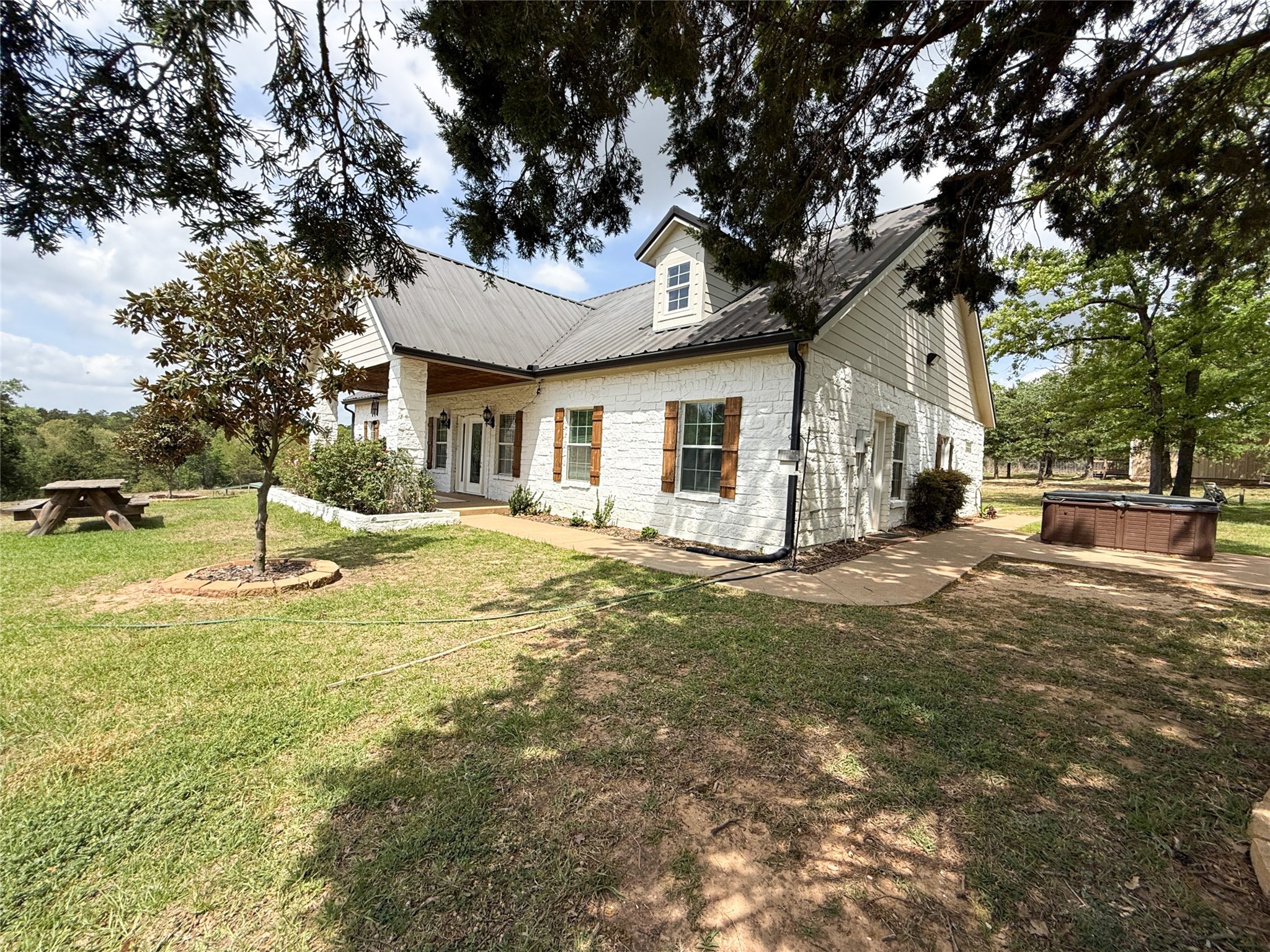 740 Bridget Avenue Buffalo, TX 75831 - Photo 5 of 50 a view of a white house next to a yard with a large tree