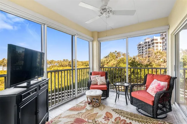a living room with furniture a flat screen tv and a floor to ceiling window