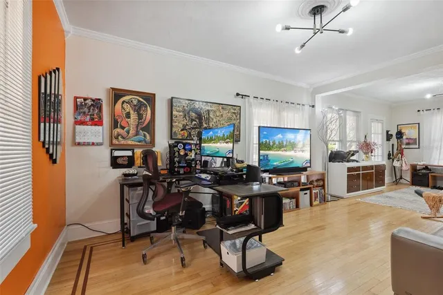 a view of a dining room with furniture one side kitchen view and wooden floor