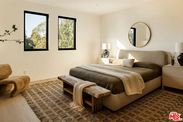 a bedroom with bed and a painting on the wall