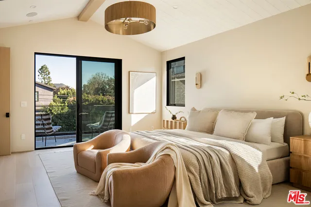 a bedroom with bed and a large window