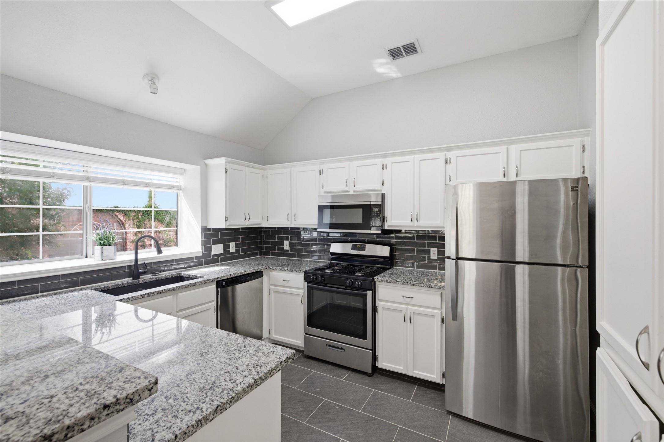 2922 Wickersham Lane Austin, TX 78741 - Photo 17 of 26 a kitchen with white cabinets and white appliances
