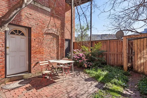 a view of a chairs and table in the backyard