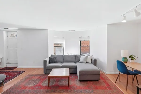 a living room with furniture and a wooden floor