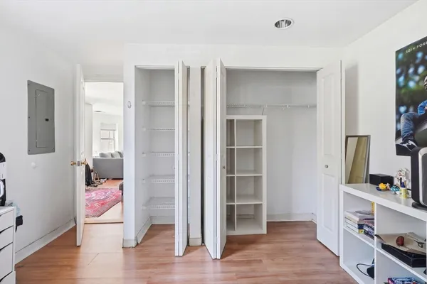 a view of a hallway view with wooden floor and cabinet