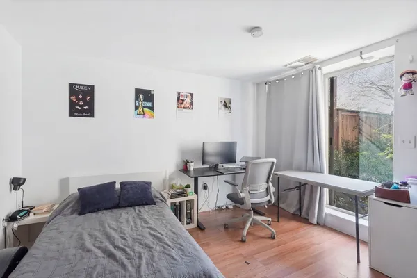 a bedroom with a bed and wooden floor