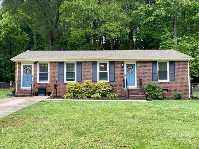 a front view of a house with yard and green space
