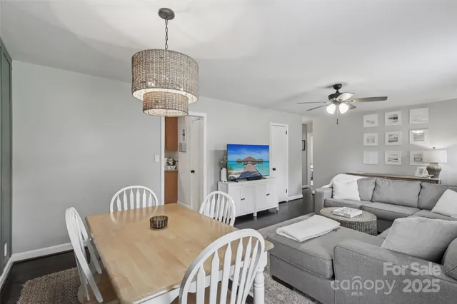 a living room with furniture a chandelier and a flat screen tv