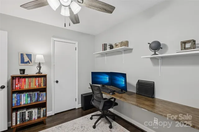 a view of a workspace with furniture and a book shelf
