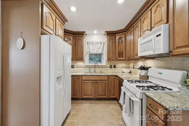 a kitchen with stainless steel appliances granite countertop a stove a refrigerator and a sink