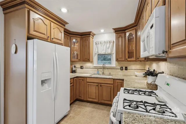 a kitchen with stainless steel appliances a refrigerator a sink and white cabinets