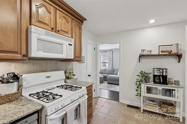 a kitchen with stainless steel appliances granite countertop a stove and a microwave