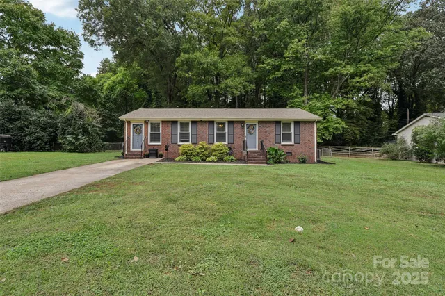 a view of a house with a backyard and a patio