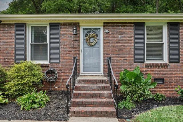 a front view of a house with potted plants
