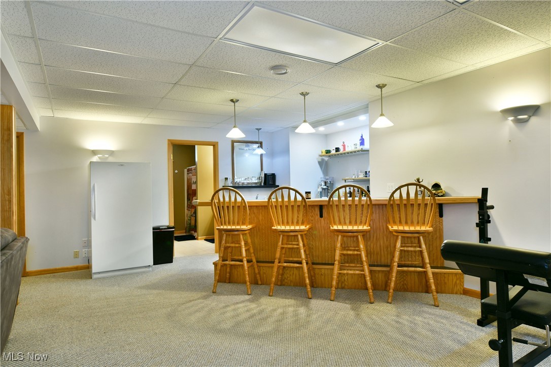 2907 Bushnell Campbell Road Fowler, OH 44418 - Photo 35 of 49 Carpeted dining room featuring bar area, a drop ceiling, and baseboards
