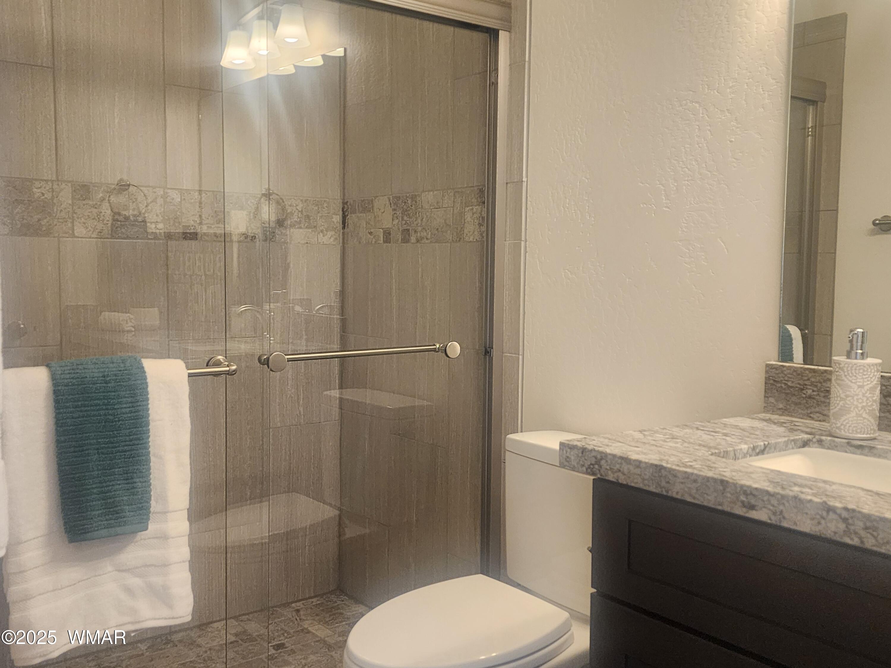 5523 Turkey Run Road Pinedale, AZ 85934 - Photo 16 of 34 a bathroom with a granite countertop sink toilet and shower
