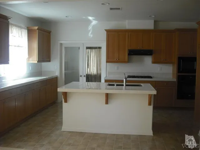 a kitchen with stainless steel appliances a sink stove and cabinets