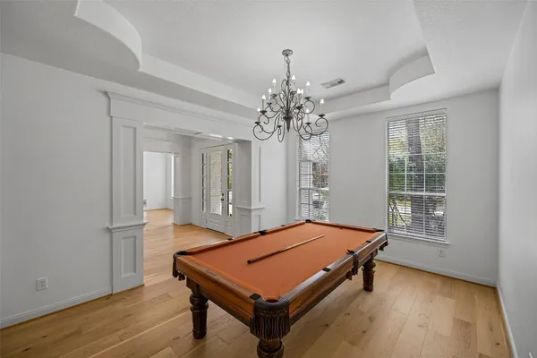 a room with pool table and windows