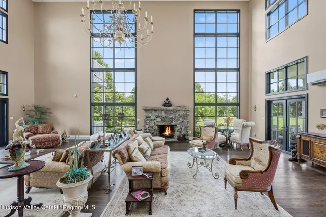 a living room with furniture kitchen view and a large window