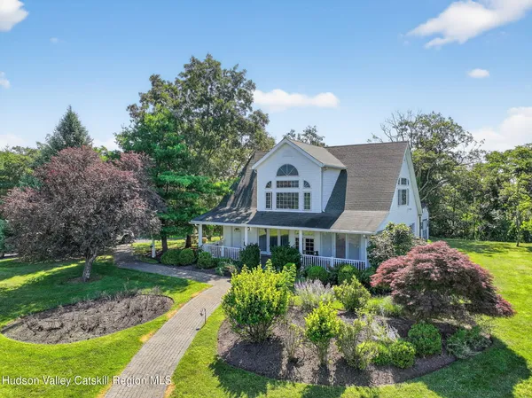 a kitchen with stainless steel appliances a dining table chairs a refrigerator and a chandelier