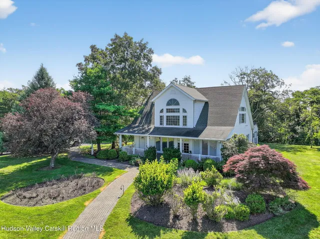 a kitchen with stainless steel appliances a dining table chairs a refrigerator and a chandelier