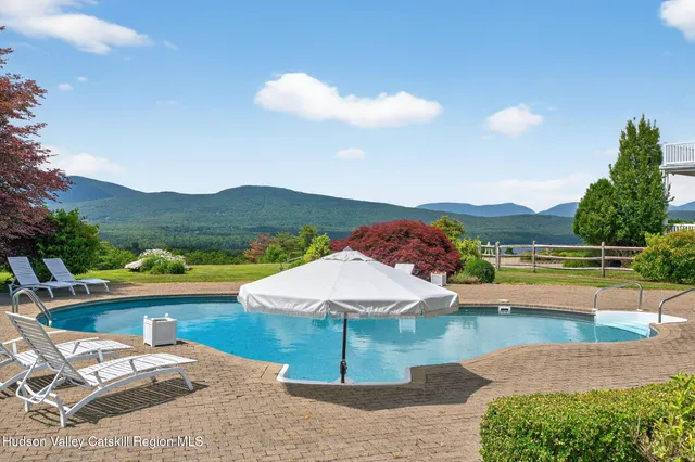 a living room with furniture large window and wooden floor