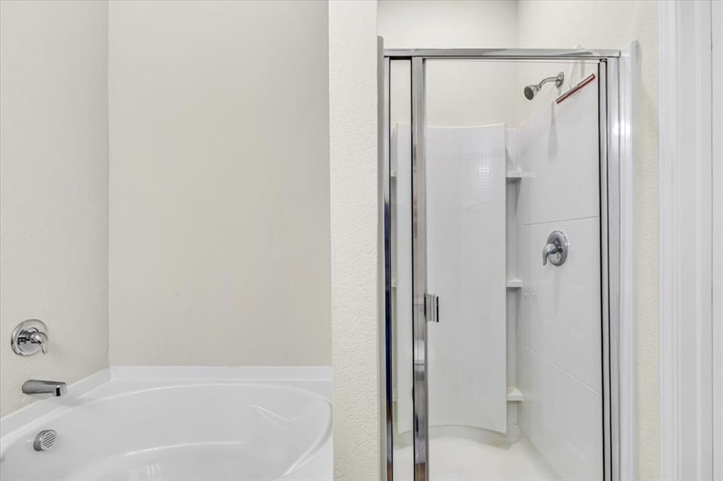 1201 Timberhurst Trail Fort Worth, TX 76131 - Photo 21 of 40 Built-in bathtub with polished chrome fixtures and an adjacent standing shower with clear glass enclosure and chrome hardware