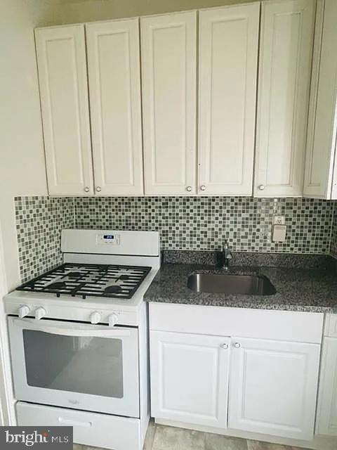 1112 North Eden Street Baltimore, MD 21213 - Photo 10 of 16 a kitchen with a stove and white cabinets