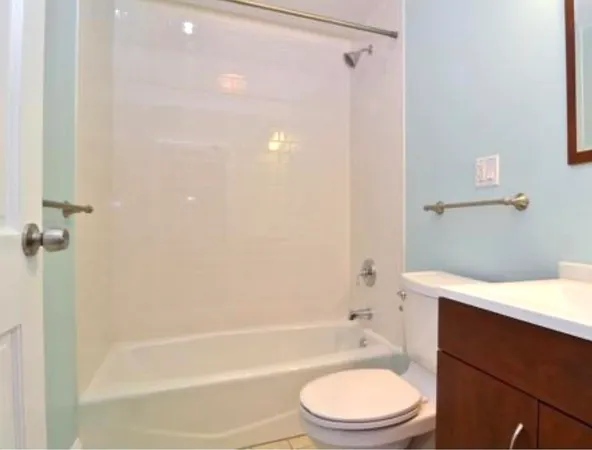 a bathroom with a bathtub shower sink vanity and a toilet