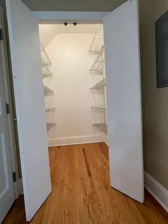 a view of walk in closet with wooden floor